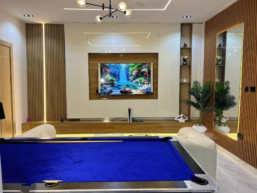 a pool table in a living room with a painting at Shortletbylolami in Mama