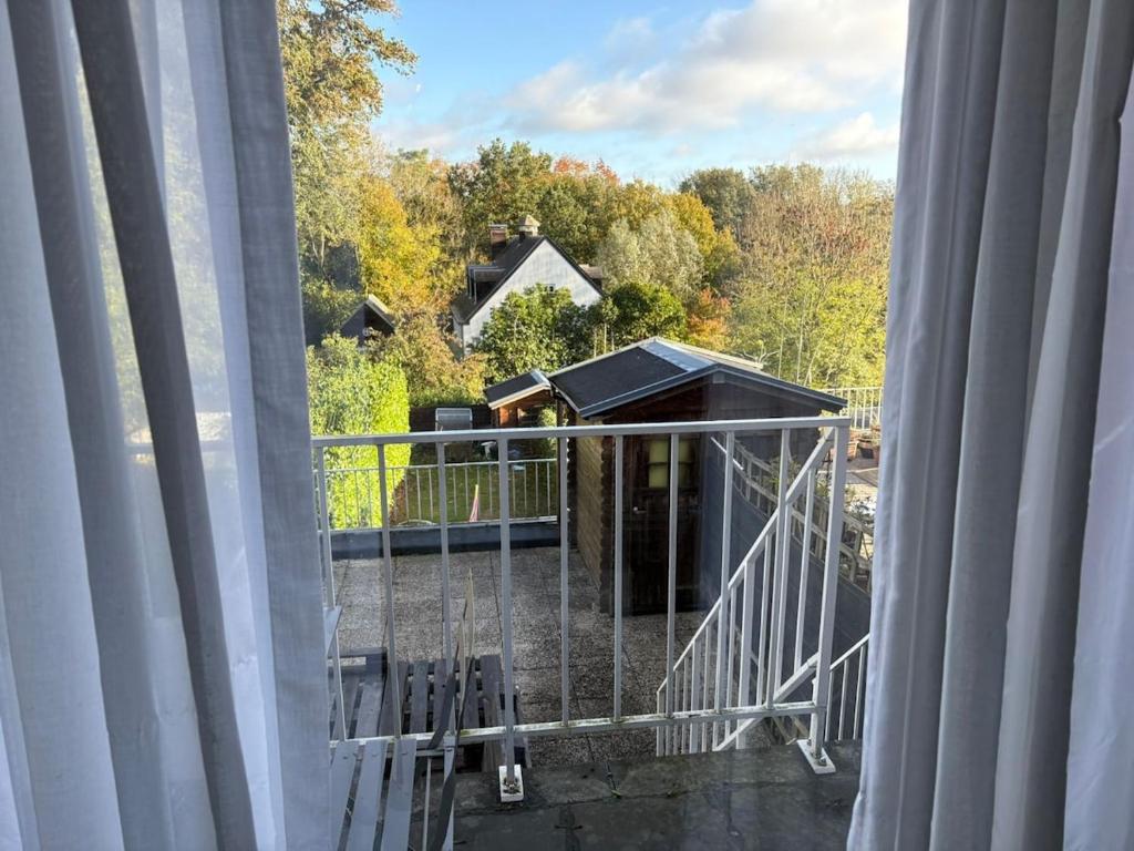 a balcony with a view of a house with trees at A 15 min de l'entrée de Bruxelles in Rixensart