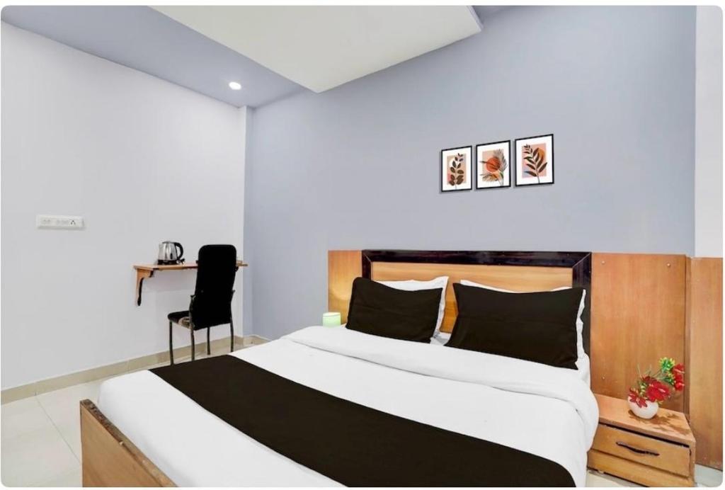 um quarto com uma cama grande e uma escrivaninha em Collection O High Court Lucknow em Vibhuti Khand
