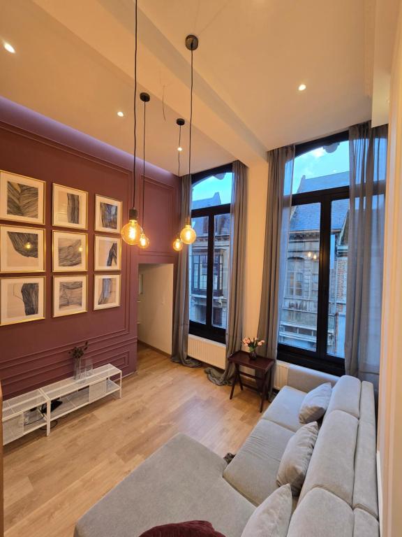 a living room with a couch and large windows at memore in Mons