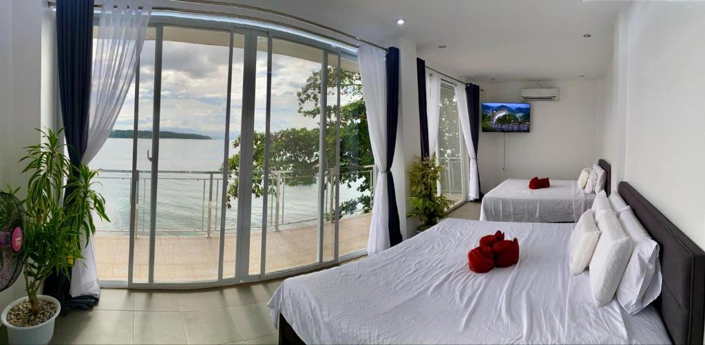 Una habitación de hotel con dos camas y balcón. en Villa Talisay Ocean View, en Samal
