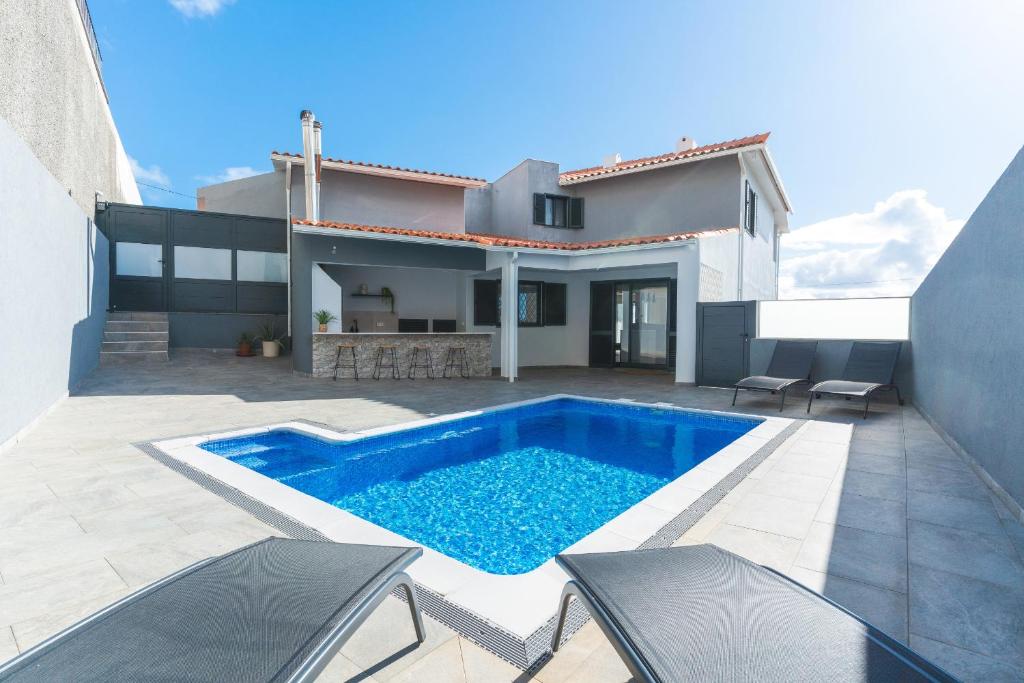 a swimming pool in the backyard of a house at Breeze House 1 by Atlantic Holiday in Garajau