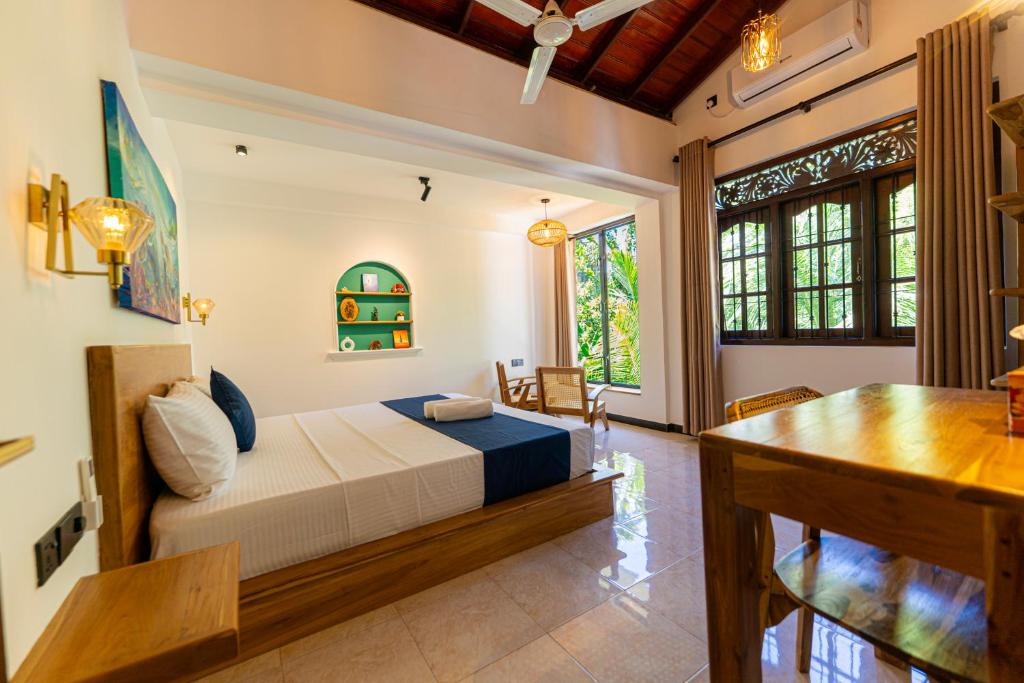 a bedroom with a bed and a desk in a room at Breeze Bay Villa in Dickwella