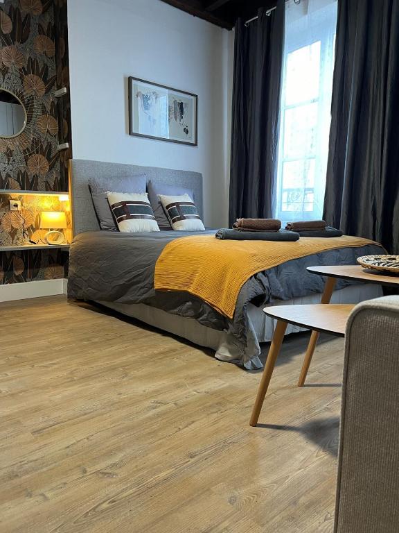 a bedroom with a large bed with a yellow blanket at Studio Bourgogne 30 in Orléans