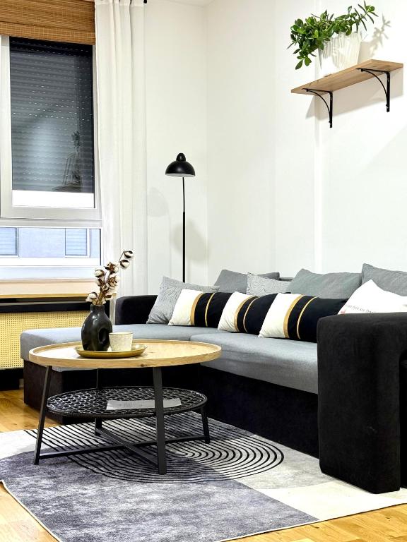 una sala de estar con un sofá y una mesa en Apartman Mir, en Temerin