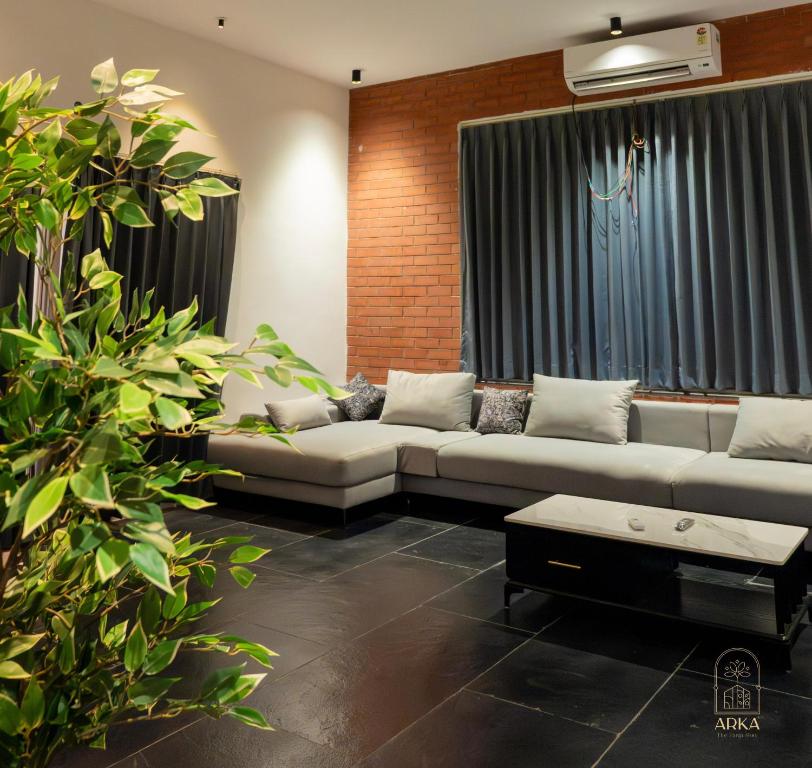 商沙巴ARKA The Farm Stay的客厅配有沙发和植物