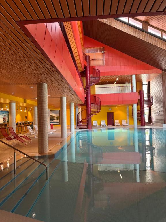 3,5 a San Bernardino con Piscina Condominiale في سان برناردينو: حمام سباحة في مبنى مع كراسي وسلالم