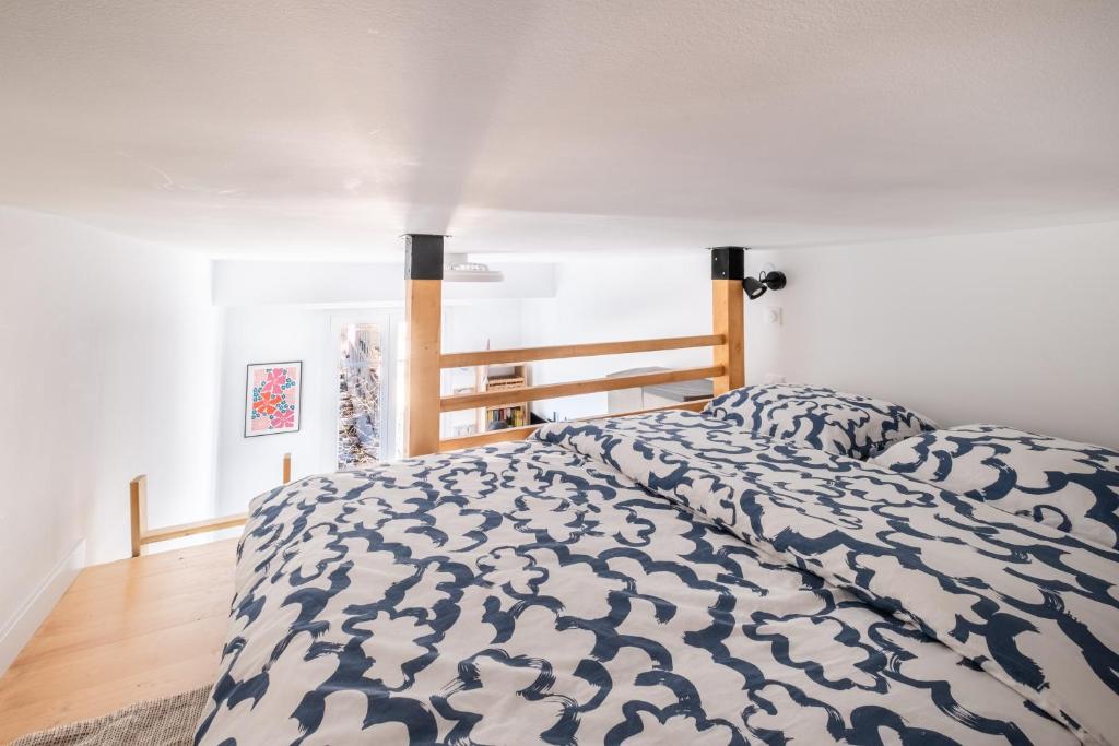a bedroom with a bed with a blue and white comforter at The cozy corner of Amelie in Nice