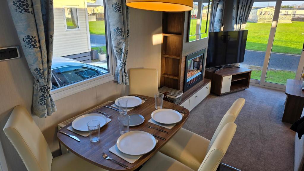 een eetkamer met een tafel en een tv bij Cranfield Bay Getaway in Kilkeel