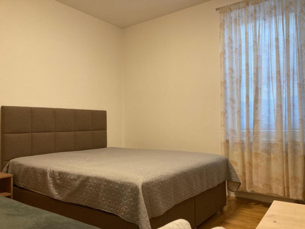 a bedroom with a bed and a large window at Apartmány Ševcovská in Zlín