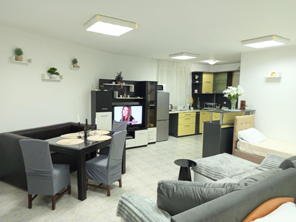 a living room with a dining table and a kitchen at Alena'Studio in Gabrovo