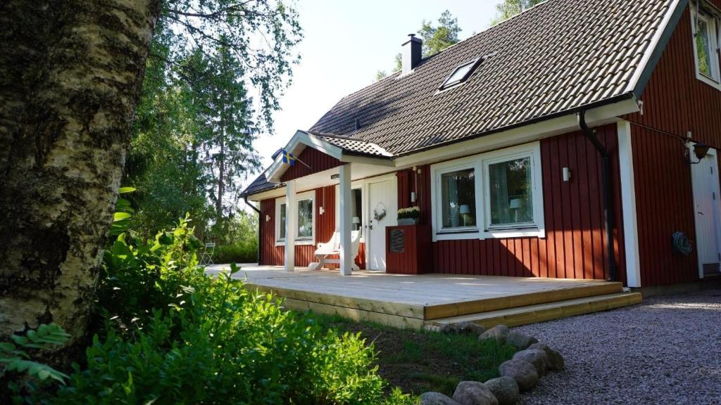 a red and white house with a porch at Landhaus Måsberget in Kristinehamn