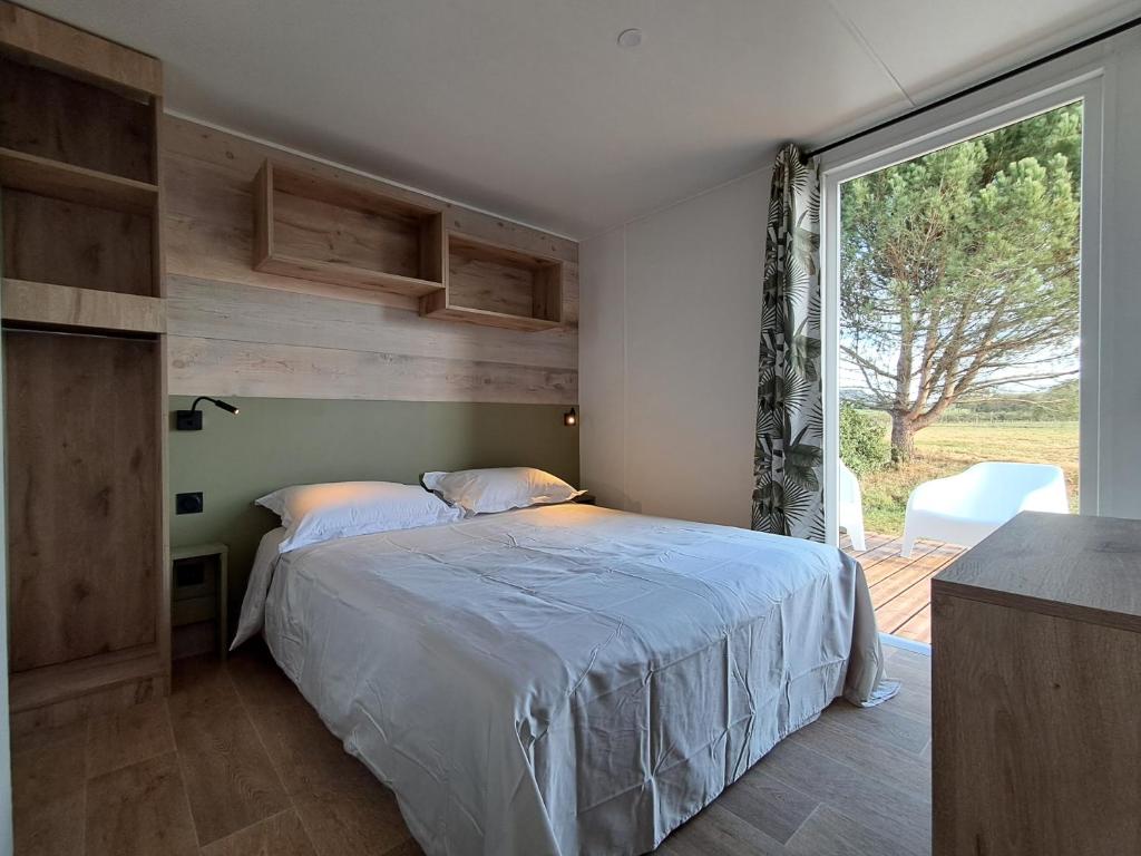 une chambre avec un lit et une grande fenêtre dans l'établissement Suite Hôtel, à Le Temple-sur-Lot