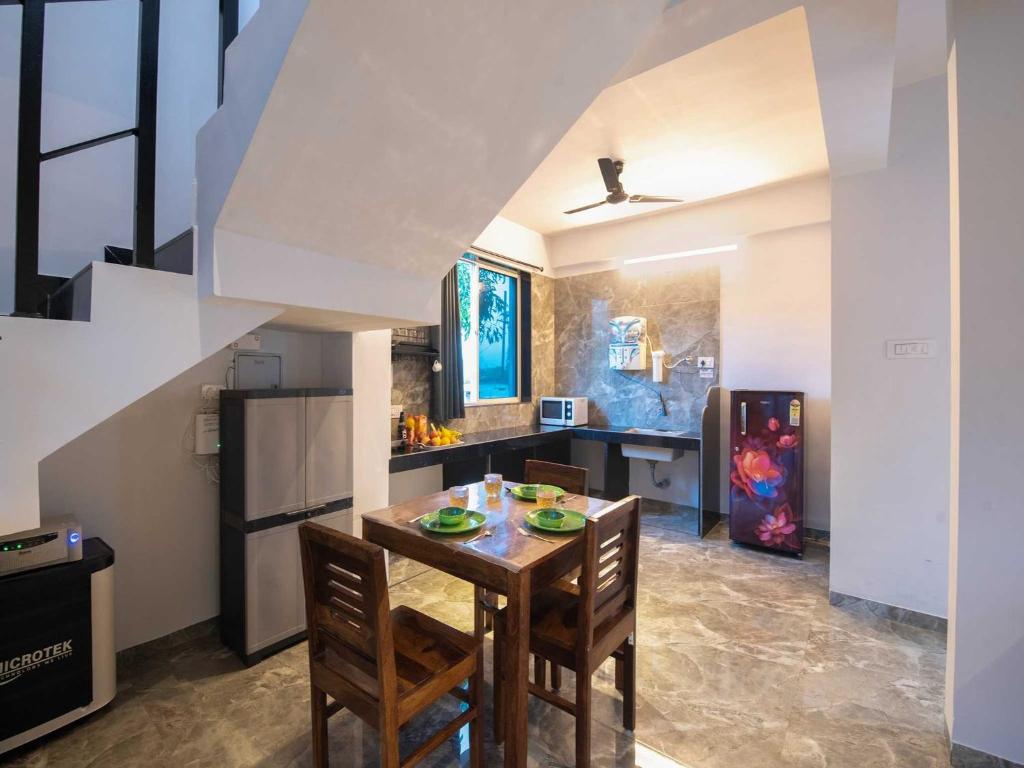 uma cozinha com mesa e cadeiras em uma sala em Ventara Bliss Bungalow by Palette | Pvt Pool | Lonavala em Kārli