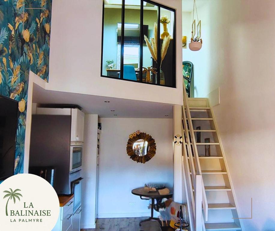 - un escalier dans une maison avec un miroir sur le mur dans l'établissement La Balinaise, aux Mathes
