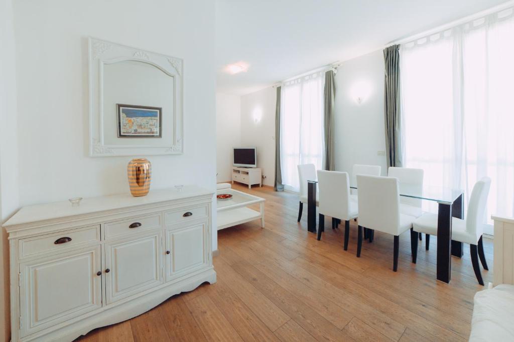 a white dining room with a table and chairs at Residence Porta Saragozza in Bologna