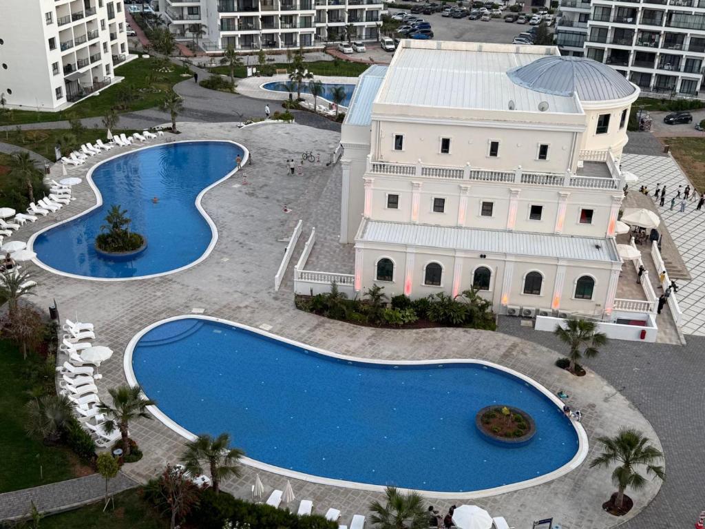 an aerial view of two swimming pools in front of a building at Caesar Resort & SPA & Apartments Spacious Studio in Avgorou