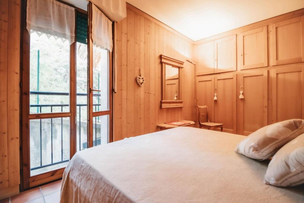 a bedroom with a bed and a large window at Bormio 5 min - Casa Simona with Wifi and FreePark in Valdisotto