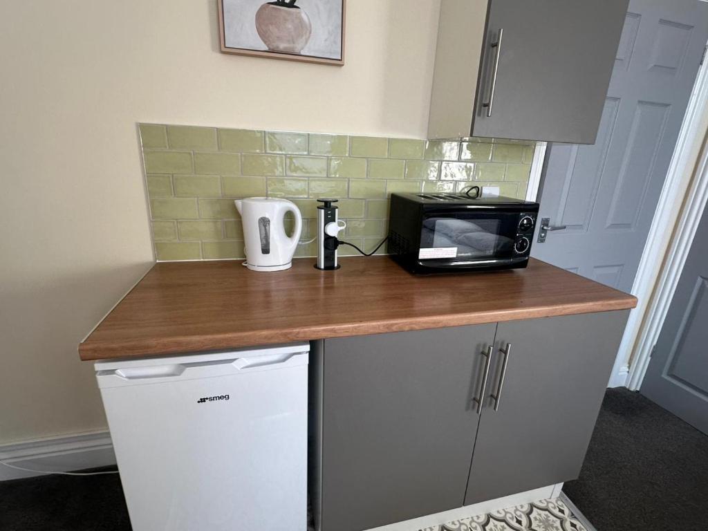 a kitchen counter with a microwave and a coffee maker at Modern Studio Close to City Centre in Newcastle upon Tyne
