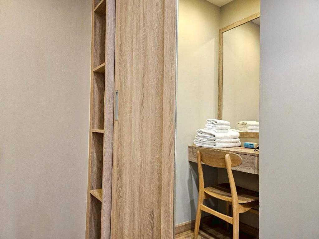 A compact dressing desk and chair beside an open wardrobe.