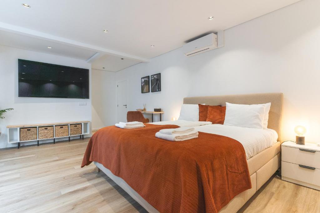 ein Schlafzimmer mit einem großen Bett, auf dem Handtücher liegen in der Unterkunft Breeze House 2 by Atlantic Holiday in Garajau