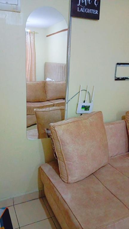 a living room with a couch and a mirror at DnC Homes in Nairobi