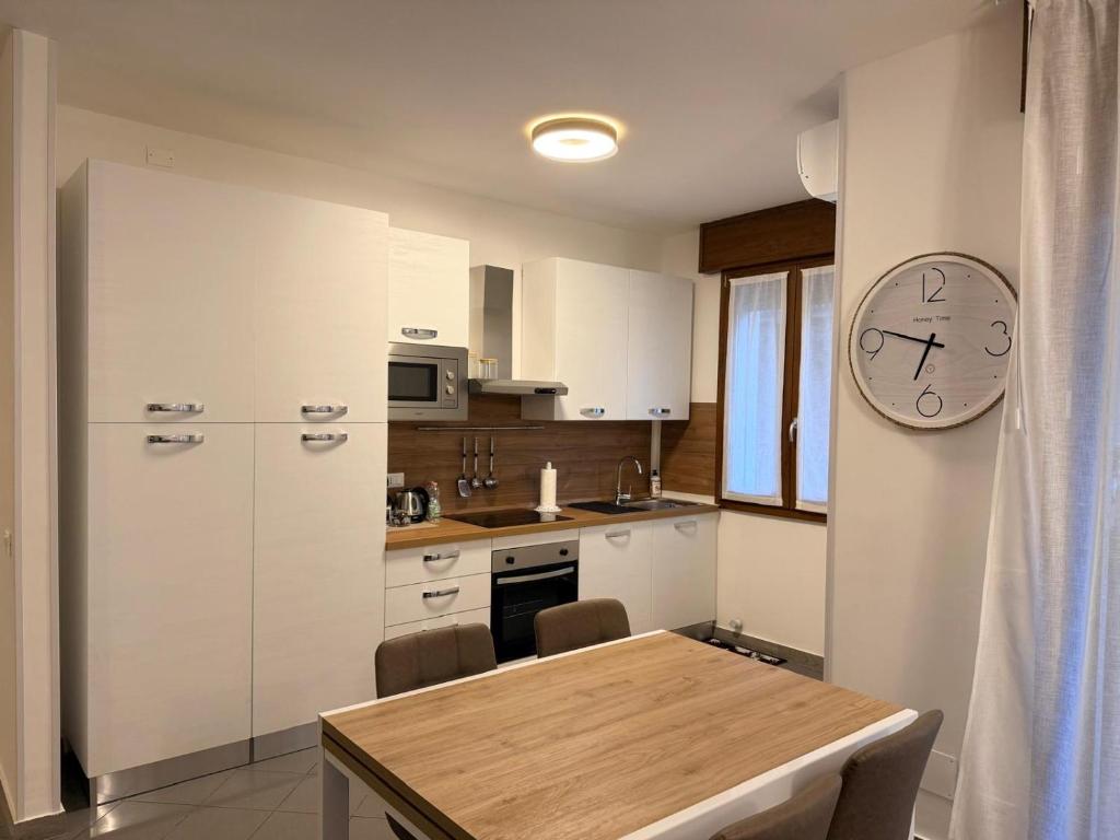 a kitchen with a table and a clock on the wall at Casa da Luigina 2 in Chioggia