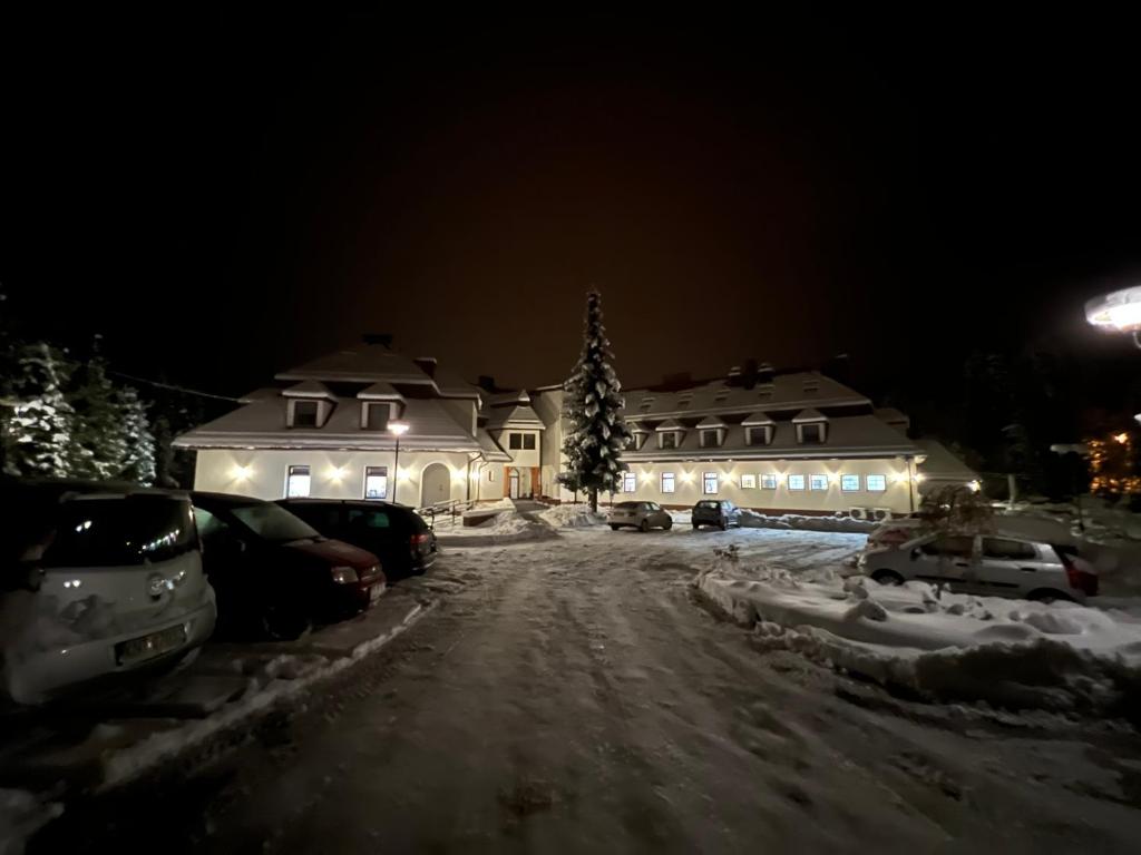 a house with cars parked in the snow at night at GORCZAŃSKA PERŁA Łopuszna Podhale in Łopuszna