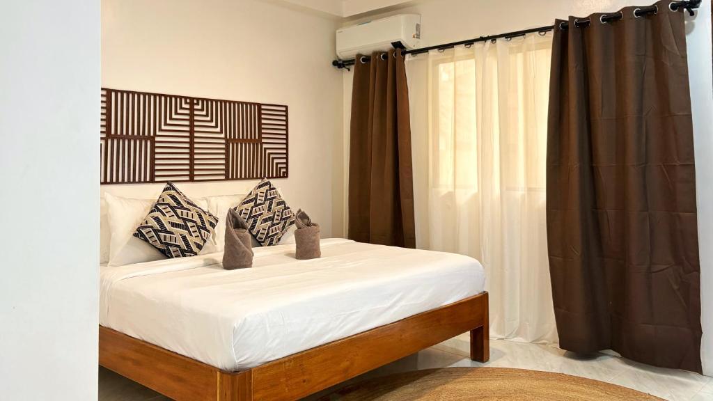 1 dormitorio con 1 cama con sábanas y cortinas blancas en Villa Aniani, en El Nido