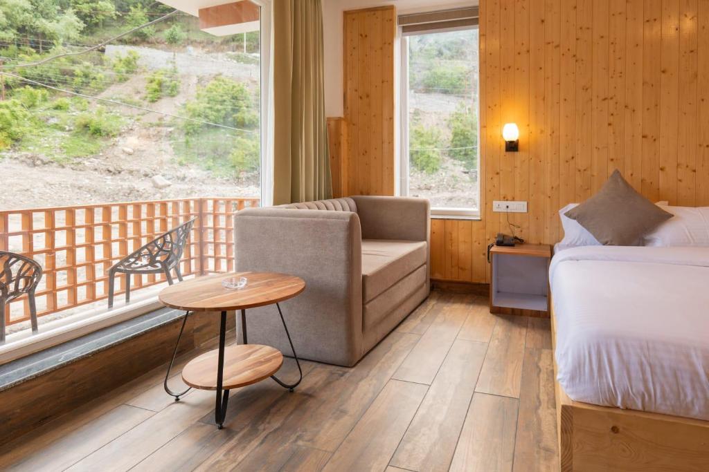 Un dormitorio con una cama, un sofá y una mesa. en Hotel Patalsu, en Palchān