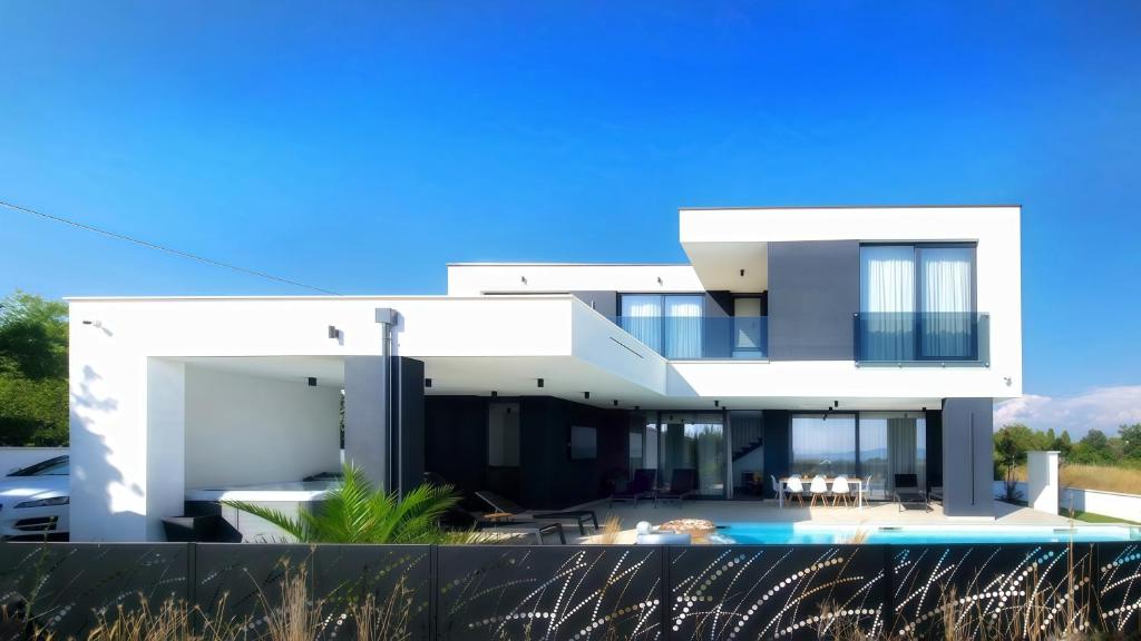 a large white house with a swimming pool at Villa 1 in Kožino