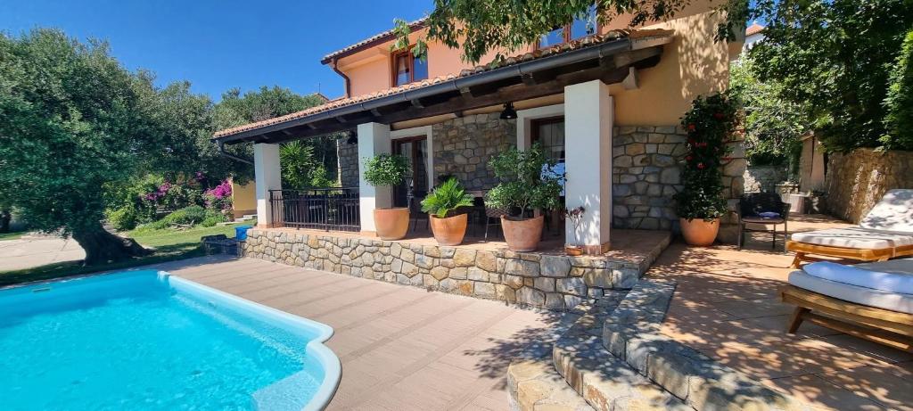 ein Haus mit einem Swimmingpool im Hof in der Unterkunft Villa Rapkinja in Mundanije