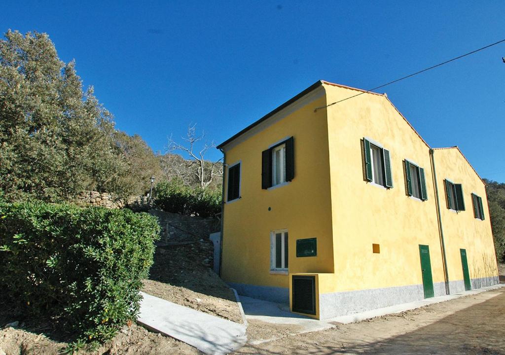 a small yellow building with ajar doors on it at Sansone Sul Mare Appartamenti in Portoferraio