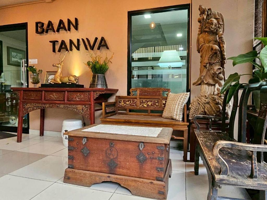 A lobby corner styled with carved furniture, a bench and a wooden chest.