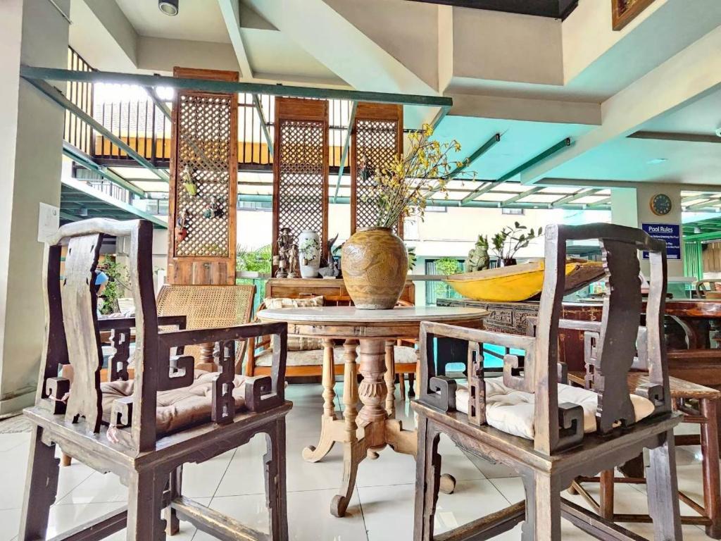 A traditional dining area arranged around wooden tables and carved chairs.