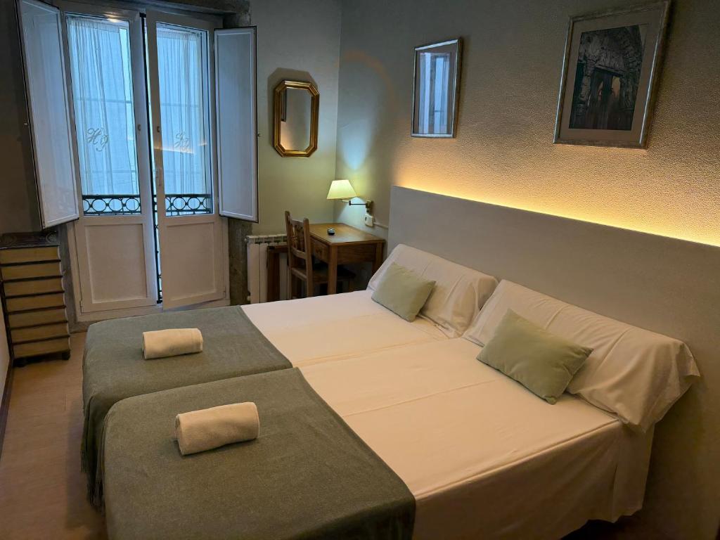 une chambre avec un lit avec deux oreillers dessus dans l'établissement Hotel Real, à Saint-Jacques-de-Compostelle