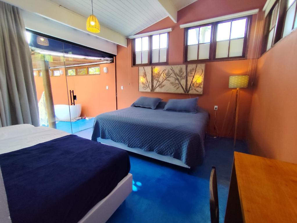 瓜拉雷马Charmosa casa na Estação Ferroviária de Luís Carlos的一间卧室，配有两张床、一张桌子和窗户