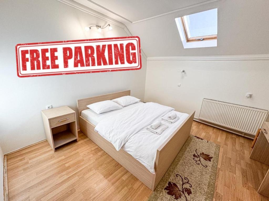 a small bedroom with a free parking sign on the wall at Guest house Vila Bor in Novi Sad