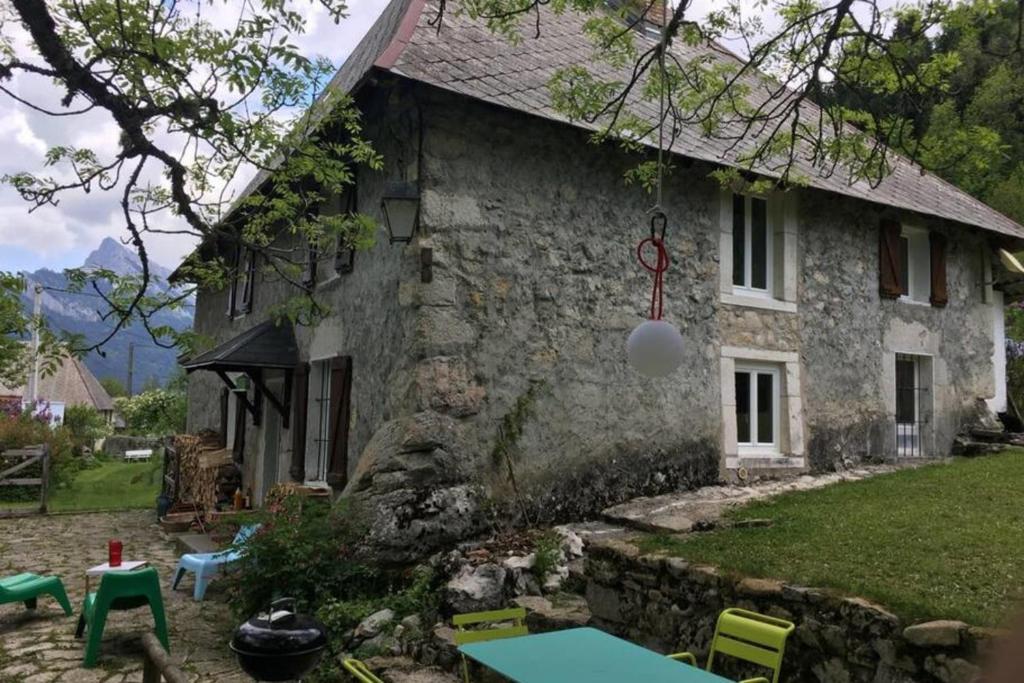una casa in pietra con un tavolo di fronte di Charmante maison familiale a Saint-Pierre-de-Chartreuse