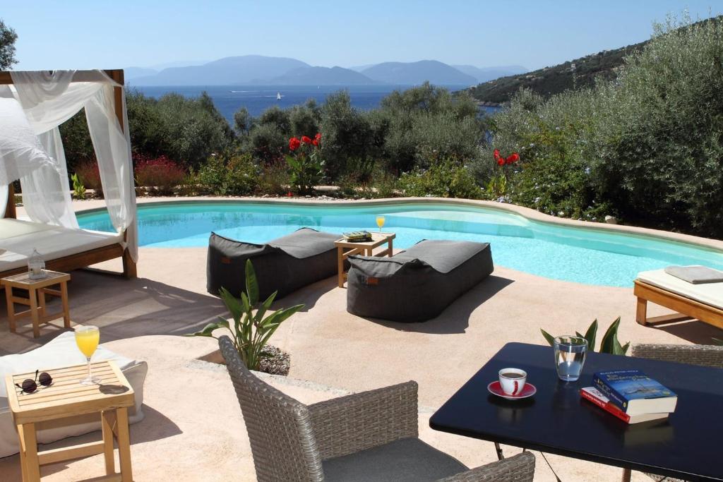 a patio with a pool and a table and chairs at Villa Agapi - Spacious Boutique Villa with Private Pool close to the sea in Sivota