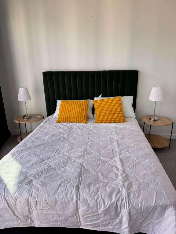 a bedroom with a large bed with two side tables at 1Br City View apt near SthnCrs Wifi Pool Gym in Melbourne