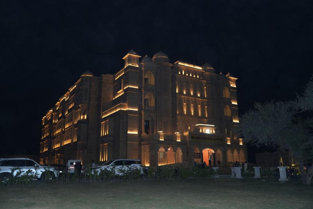 a large building with lights on it at night at Abhushan Mahal in Nīmri