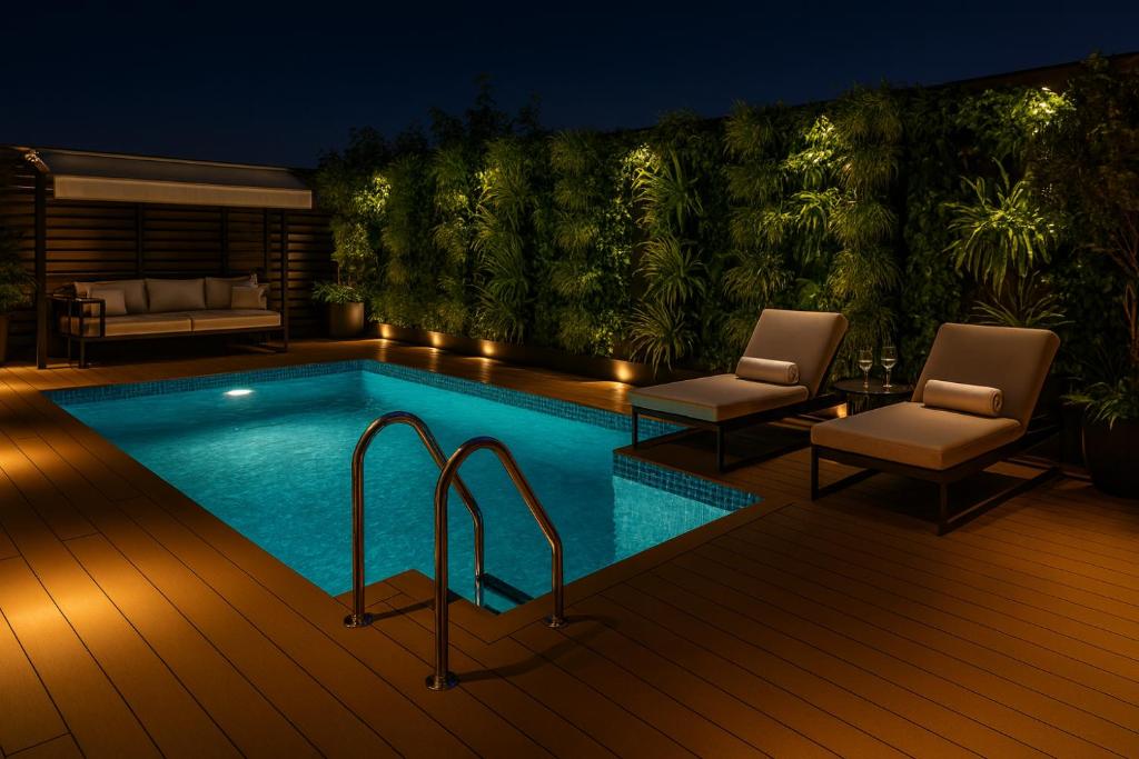 Una piscina con dos sillas y un sofá en una terraza. en Hotel Golden Temple View - Best Property of Amritsar 2024-25, en Amritsar