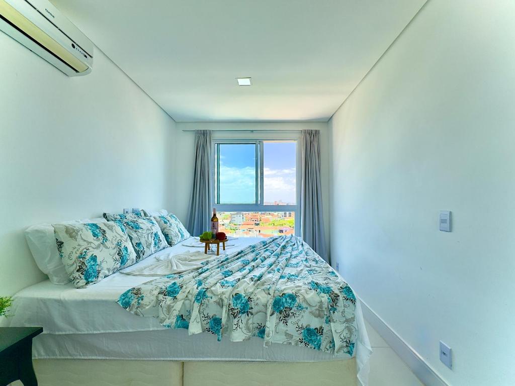 a bedroom with a bed and a window at Apartamento em condomínio HOME CLUB, cozinha completa, PISCINA e JACUZZI aquecida, SAUNA, ACADEMIA, quadra de esportes playground infantil, salão de jogos a 40m da PRAIA e 15min do Beto Carreiro in Piçarras