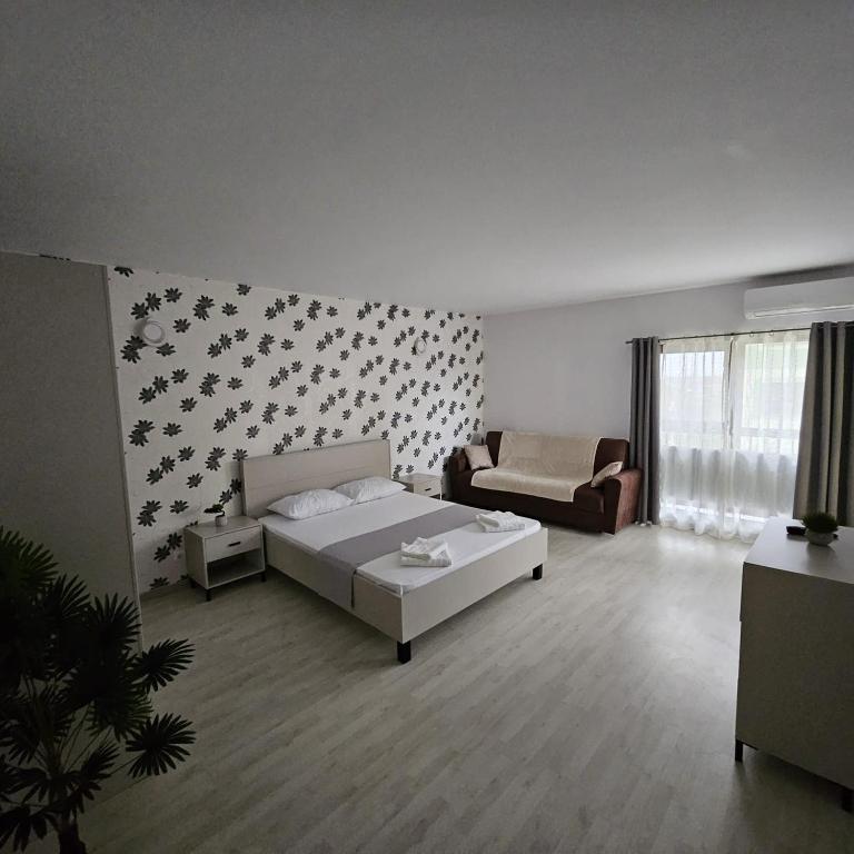 a living room with a bed and a couch at Lovely apartment in Craiova