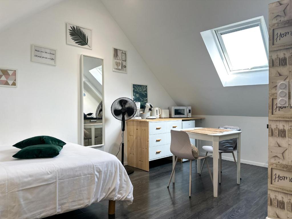 a bedroom with a bed and a desk and a table at Studio Cocoon - Calme et confortable in Lorient