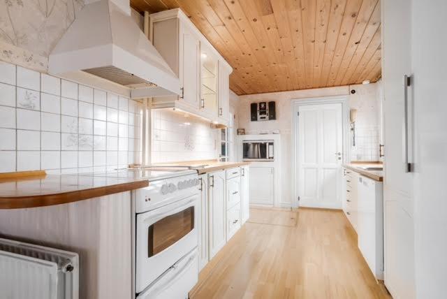 灵克宾Charming Townhouse By The Harbour的一间厨房,配有白色家电和木制天花板