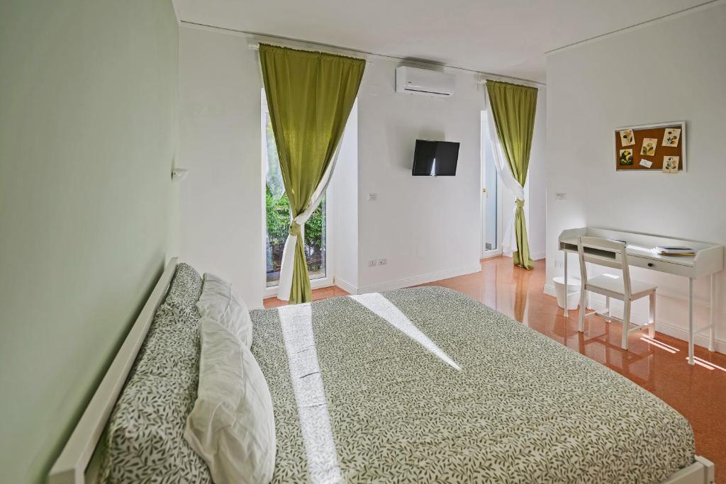 Un dormitorio con una cama y un escritorio y una ventana. en Verdelia, en Giffoni Valle Piana