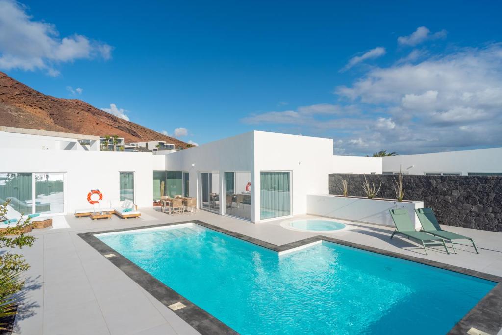 a villa with a swimming pool and a patio at Ereza Hoopoe Villas in Playa Blanca