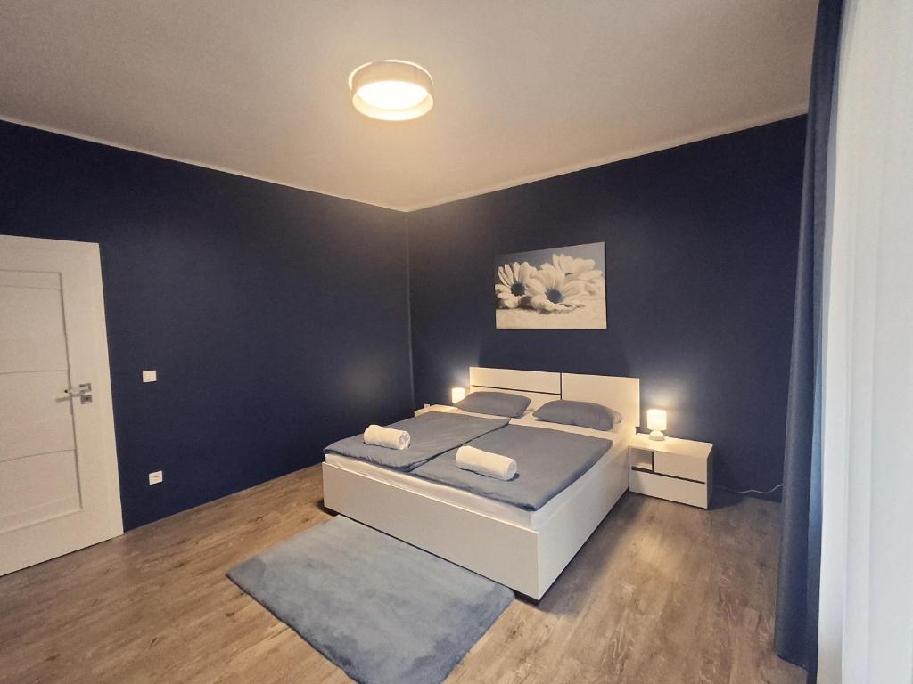 a bedroom with a bed and a blue wall at SZEDERMÁLNA Vendégház in Sárospatak